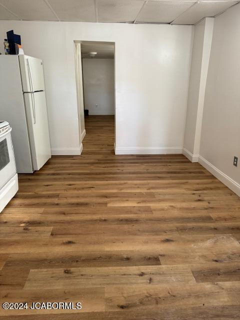 interior space featuring a drop ceiling and hardwood / wood-style flooring