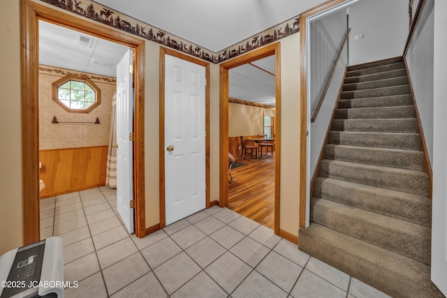990 Diamond Rdg, Jefferson City, MO 65109 - entryway featuring visible vents, wainscoting, wooden walls, stairs, and light tile patterned flooring