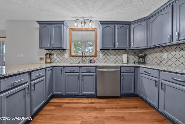 990 Diamond Rdg, Jefferson City, MO 65109 - kitchen featuring light stone counters, a sink, light wood-style floors, decorative backsplash, and stainless steel dishwasher