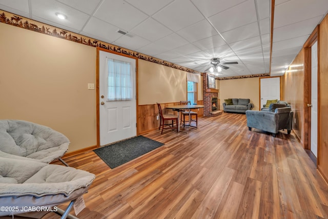 990 Diamond Rdg, Jefferson City, MO 65109 - living area featuring visible vents, wood finished floors, a fireplace, a paneled ceiling, and a ceiling fan
