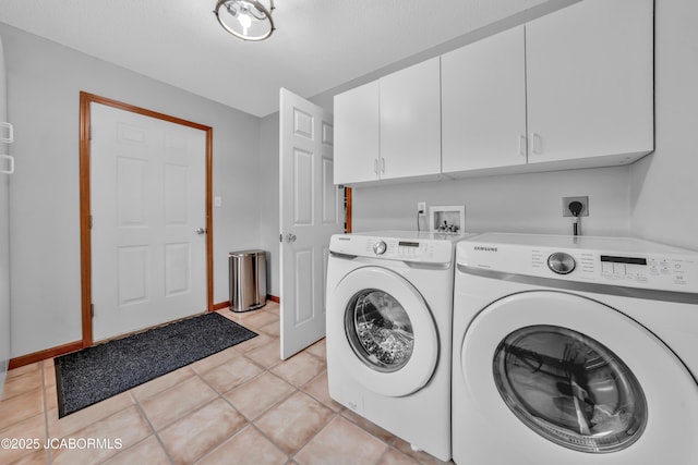 990 Diamond Rdg, Jefferson City, MO 65109 - clothes washing area with washing machine and clothes dryer, baseboards, light tile patterned floors, and cabinet space