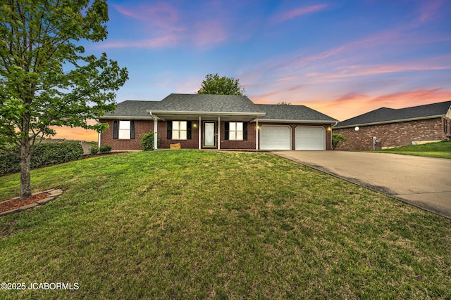 990 Diamond Rdg, Jefferson City, MO 65109 - ranch-style home featuring covered porch, driveway, a lawn, brick siding, and an attached garage