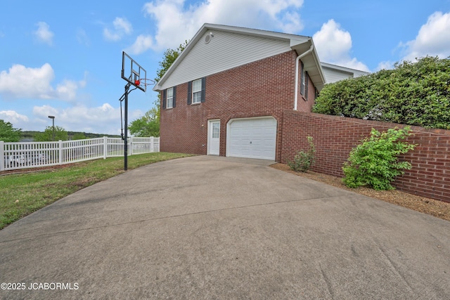 990 Diamond Rdg, Jefferson City, MO 65109 - view of side of home featuring brick siding, an attached garage, fence, and concrete driveway