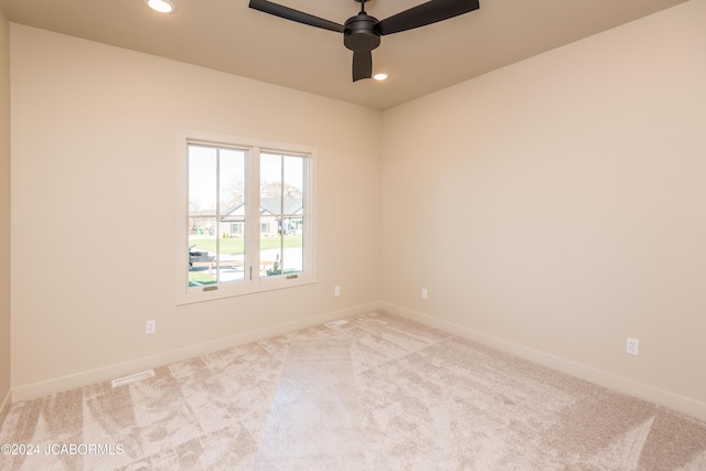 unfurnished room featuring light colored carpet and ceiling fan