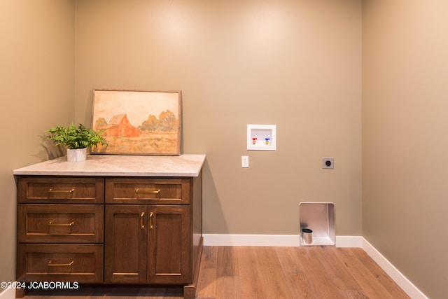 laundry room with electric dryer hookup, light hardwood / wood-style floors, cabinets, and hookup for a washing machine