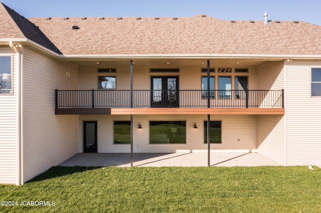 rear view of house with a patio area, a balcony, and a yard