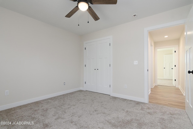 unfurnished bedroom with ceiling fan, a closet, and light colored carpet