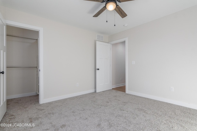 unfurnished bedroom featuring ceiling fan, light carpet, and a closet