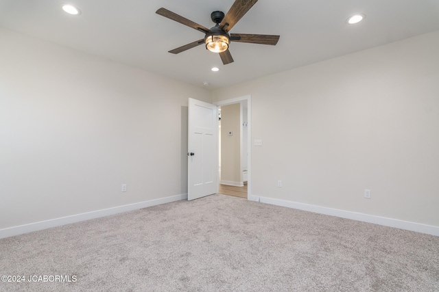 spare room with ceiling fan and light colored carpet