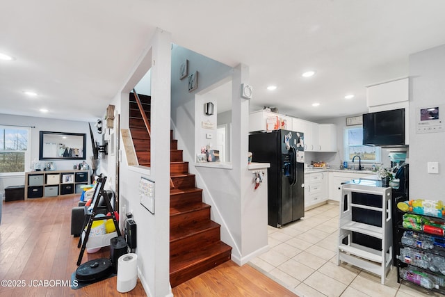 kitchen featuring white cabinetry, plenty of natural light, black fridge, and sink