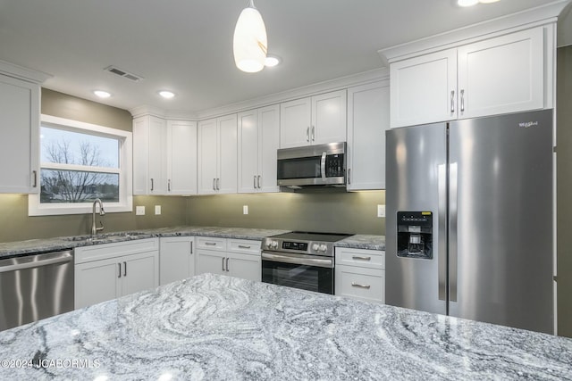 kitchen with white cabinetry, sink, hanging light fixtures, and appliances with stainless steel finishes