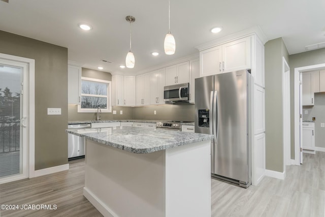 kitchen with light hardwood / wood-style floors, a center island, white cabinetry, and stainless steel appliances