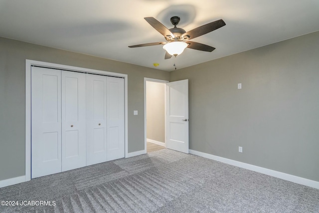 unfurnished bedroom featuring ceiling fan, a closet, and carpet