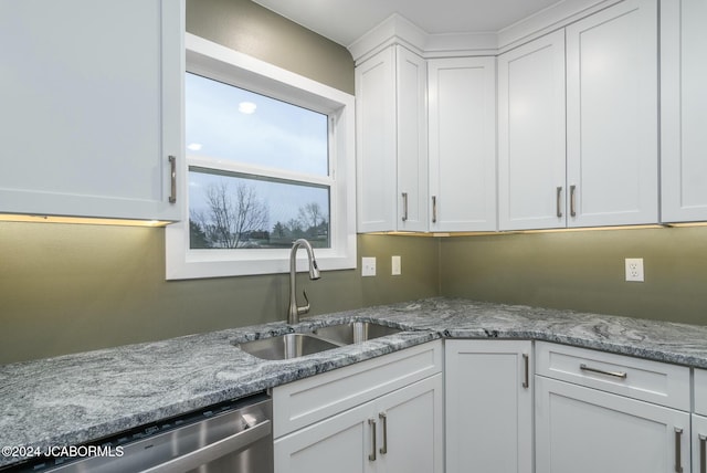 kitchen featuring white cabinetry, sink, dishwasher, and light stone countertops