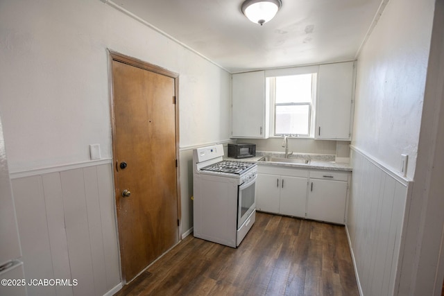 210 E Dunklin St, Jefferson City, MO 65101 - kitchen featuring white range with gas cooktop, a sink, dark wood-style floors, black microwave, and light countertops