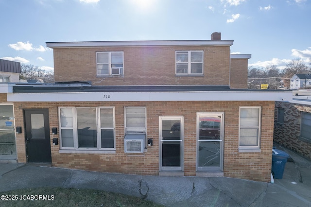 210 E Dunklin St, Jefferson City, MO 65101 - rear view of property featuring brick siding, a chimney, and cooling unit