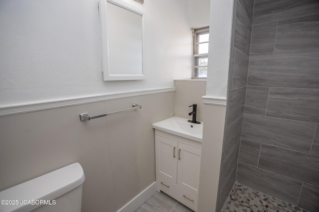 210 E Dunklin St, Jefferson City, MO 65101 - bathroom featuring vanity, toilet, a tile shower, and a wainscoted wall
