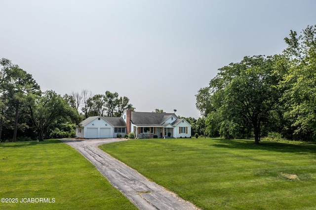 713 S Summit Dr, Holts Summit, MO 65043 - view of front facade with a front yard, a garage, a chimney, and driveway