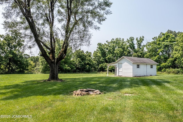 713 S Summit Dr, Holts Summit, MO 65043 - view of grassy yard featuring an outdoor structure and a fire pit