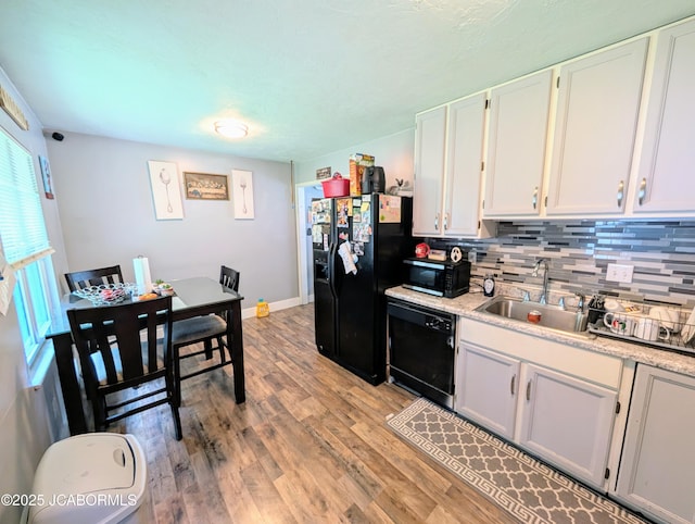 5416 S Brooks Dr, Jefferson City, MO 65109 - kitchen with black appliances, light wood finished floors, white cabinetry, and light countertops