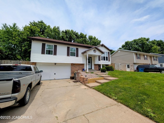 5416 S Brooks Dr, Jefferson City, MO 65109 - split foyer home with a garage, brick siding, and driveway