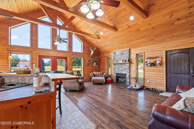 4604 County Rd 115, Fulton, MO 65251 - living area featuring a ceiling fan, high vaulted ceiling, a fireplace, wooden ceiling with exposed beams, and wooden walls