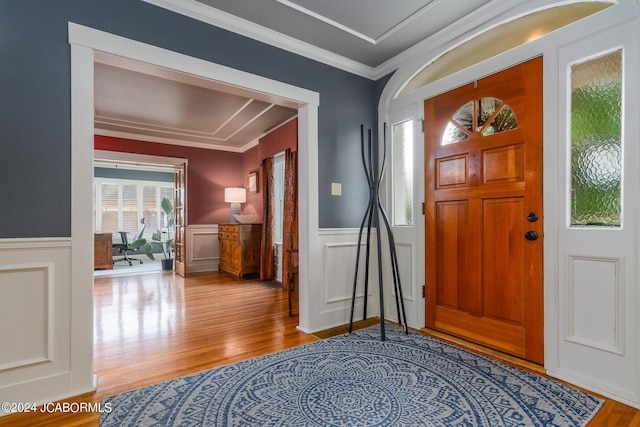 foyer with ornamental molding and light hardwood / wood-style floors