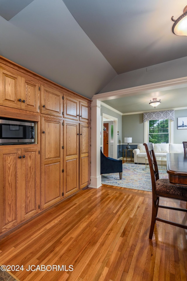 dining space with lofted ceiling, light hardwood / wood-style floors, and crown molding