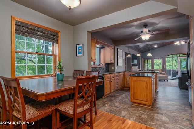 dining space with sink, lofted ceiling with beams, ceiling fan, and dark wood-type flooring