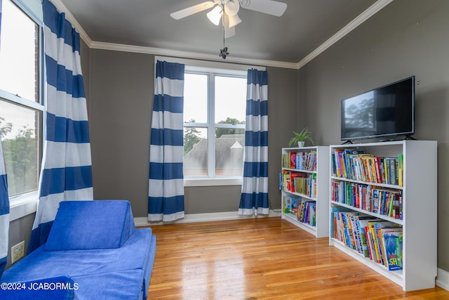 living area featuring hardwood / wood-style flooring, ceiling fan, and ornamental molding