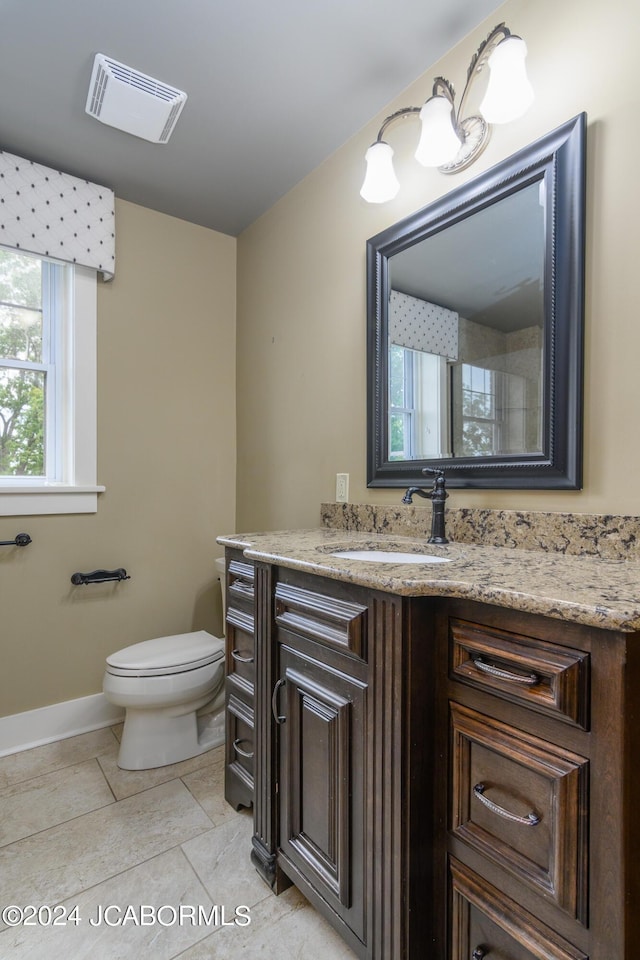 bathroom featuring toilet, tile patterned flooring, and vanity