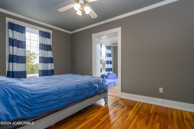 bedroom with hardwood / wood-style flooring, ceiling fan, and crown molding