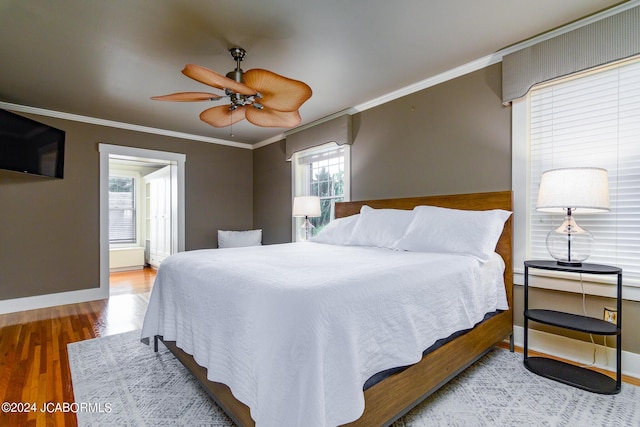 bedroom featuring hardwood / wood-style flooring, ceiling fan, and ornamental molding