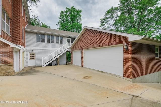 view of front of property featuring central AC and a garage