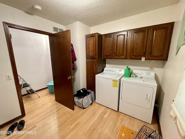 700 S Bowling St, California, MO 65018 - laundry room with washer and clothes dryer, light wood-type flooring, a textured ceiling, and cabinet space