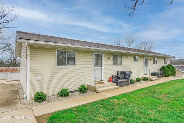view of front of home featuring fence and a front lawn