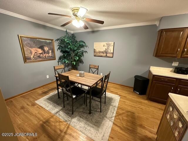 dining room with crown molding, ceiling fan, and light hardwood / wood-style flooring