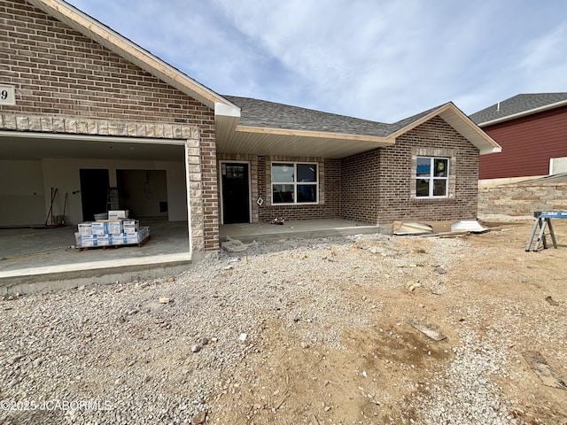 209 Gavin Ln, Linn, MO 65051 - rear view of house featuring brick siding, roof with shingles, and an attached garage