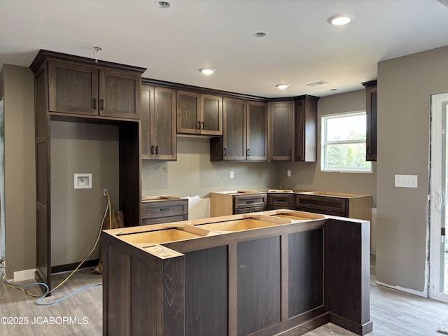 209 Gavin Ln, Linn, MO 65051 - kitchen featuring dark brown cabinets, light wood-type flooring, a kitchen island, and recessed lighting