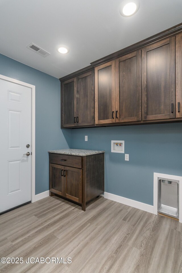 209 Gavin Ln, Linn, MO 65051 - laundry room featuring cabinet space, hookup for a washing machine, and light wood-style floors