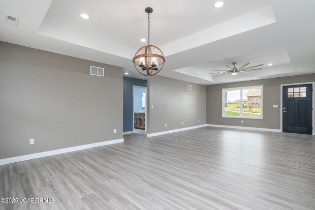 209 Gavin Ln, Linn, MO 65051 - spare room featuring a raised ceiling, recessed lighting, light wood-style floors, a chandelier, and a ceiling fan