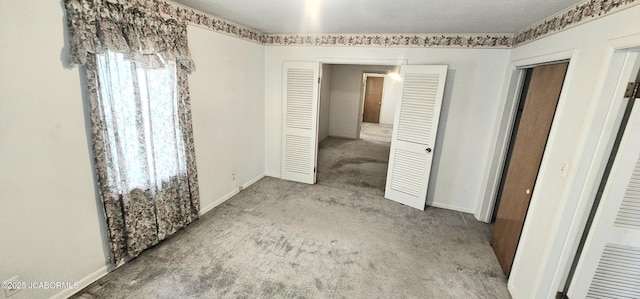 unfurnished bedroom with baseboards and carpet