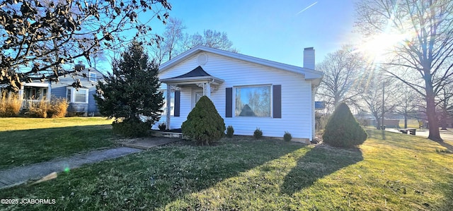 bungalow-style home with a front lawn and a chimney