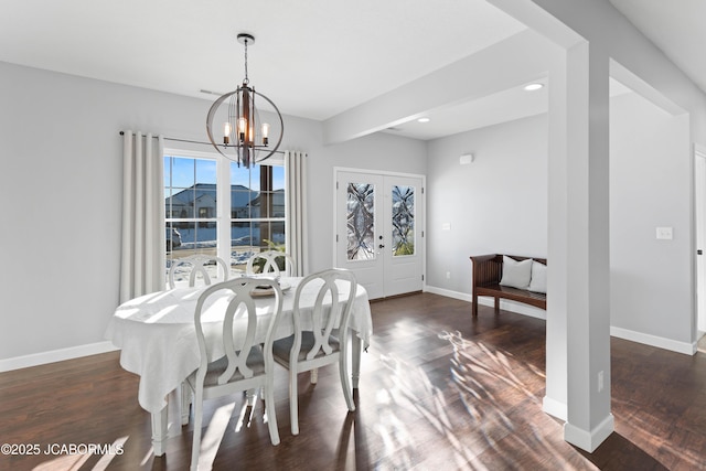 dining area with plenty of natural light, an inviting chandelier, french doors, and dark hardwood / wood-style floors