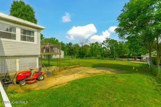 409 E 9th St, Fulton, MO 65251 - view of grassy yard with a wooden deck and view of wooded area