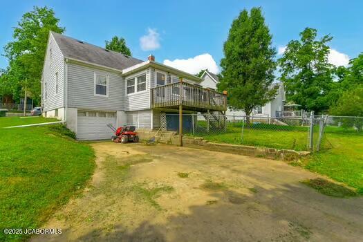 409 E 9th St, Fulton, MO 65251 - back of house featuring a deck, a garage, a chimney, and dirt driveway