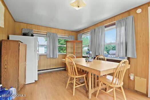409 E 9th St, Fulton, MO 65251 - dining space with baseboard heating, light wood finished floors, and wood walls