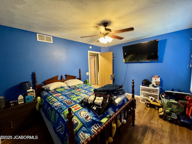 128 Don Dr, Linn, MO 65051 - bedroom featuring wood finished floors, a textured ceiling, and a ceiling fan