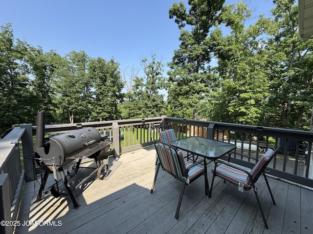 128 Don Dr, Linn, MO 65051 - wooden deck with outdoor dining space and view of wooded area