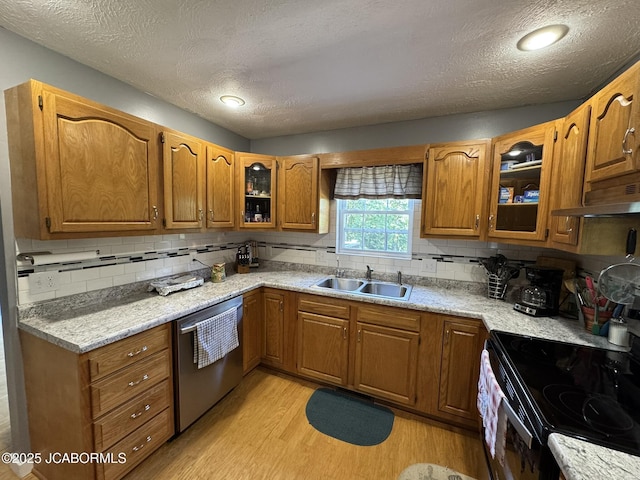 128 Don Dr, Linn, MO 65051 - kitchen featuring dishwasher, under cabinet range hood, black range with electric cooktop, brown cabinetry, and light wood finished floors